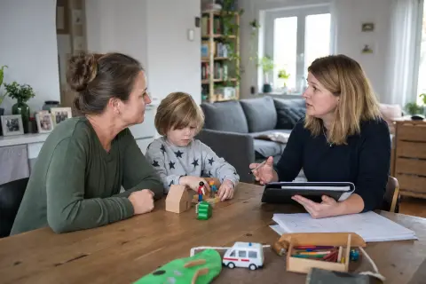 Pflegegrad bei Kindern – Voraussetzungen „Pflegegrad bei Kindern – Voraussetzungen“: Eltern und eine Fachberaterin besprechen zu Hause die Unterstützung eines pflegebedürftigen Kindes.