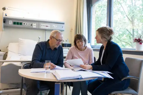 Pflegegrad im Krankenhaus beantragen – Antrag „Pflegegrad im Krankenhaus beantragen – Antrag“: Eine Pflegefachperson bespricht mit einer pflegebedürftigen Person die weitere Versorgung nach einer Behandlung.