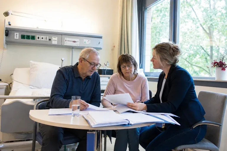 „Pflegegrad im Krankenhaus beantragen – Antrag“: Eine Pflegefachperson bespricht mit einer pflegebedürftigen Person die weitere Versorgung nach einer Behandlung.